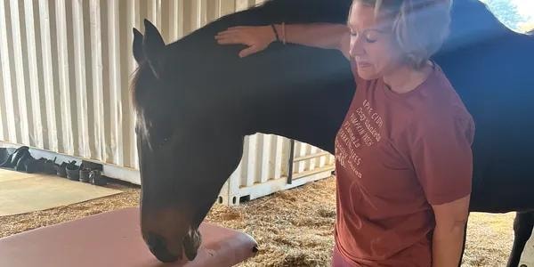 Ashley with a horse during a pet healing session