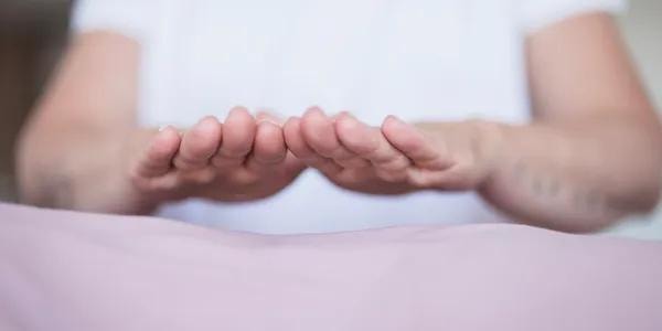 Hands in Reiki healing position during training
